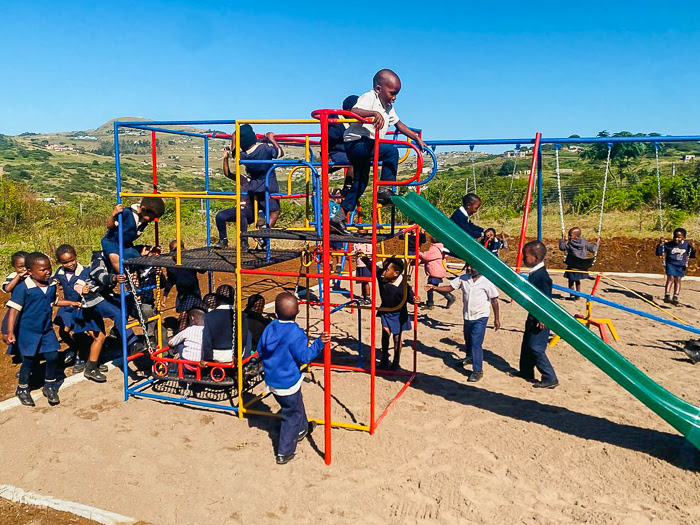 Kinder spielen auf dem neuen Spielplatz der Mandawe Primary School.
